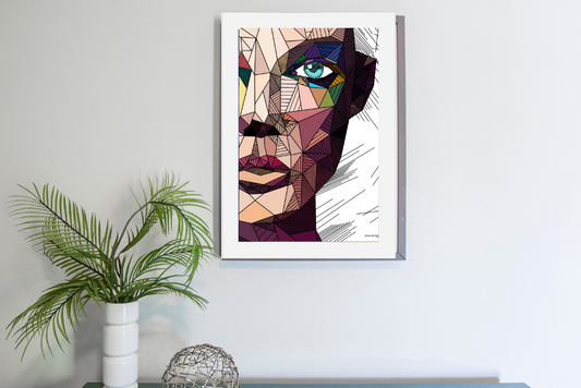 Framed geometric abstract portrait with colorful angular shapes hanging on white wall above table with plant and decorative sphere