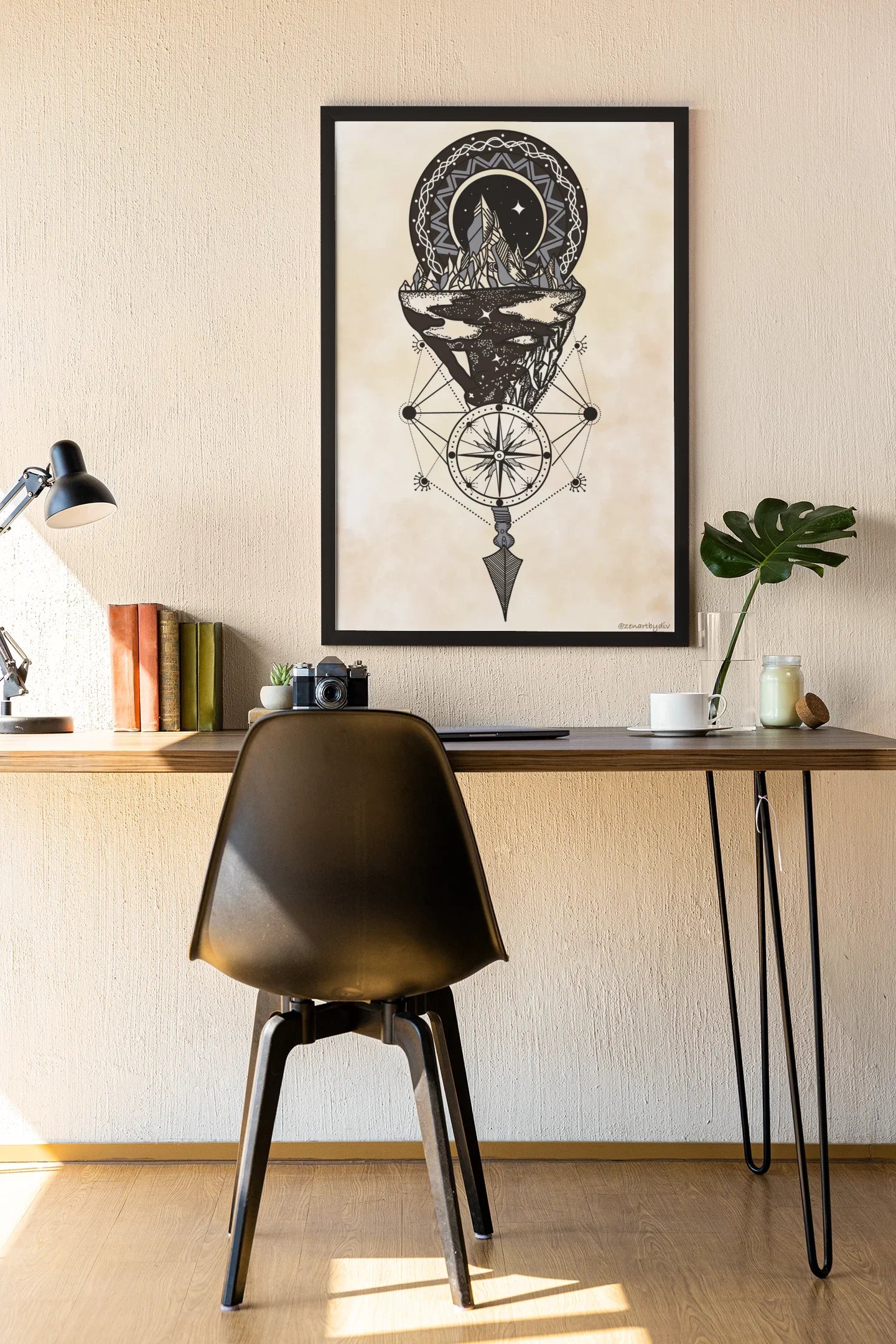 Minimalist workspace with black chair, wooden desk, geometric mountain art print, lamp, books, and plant