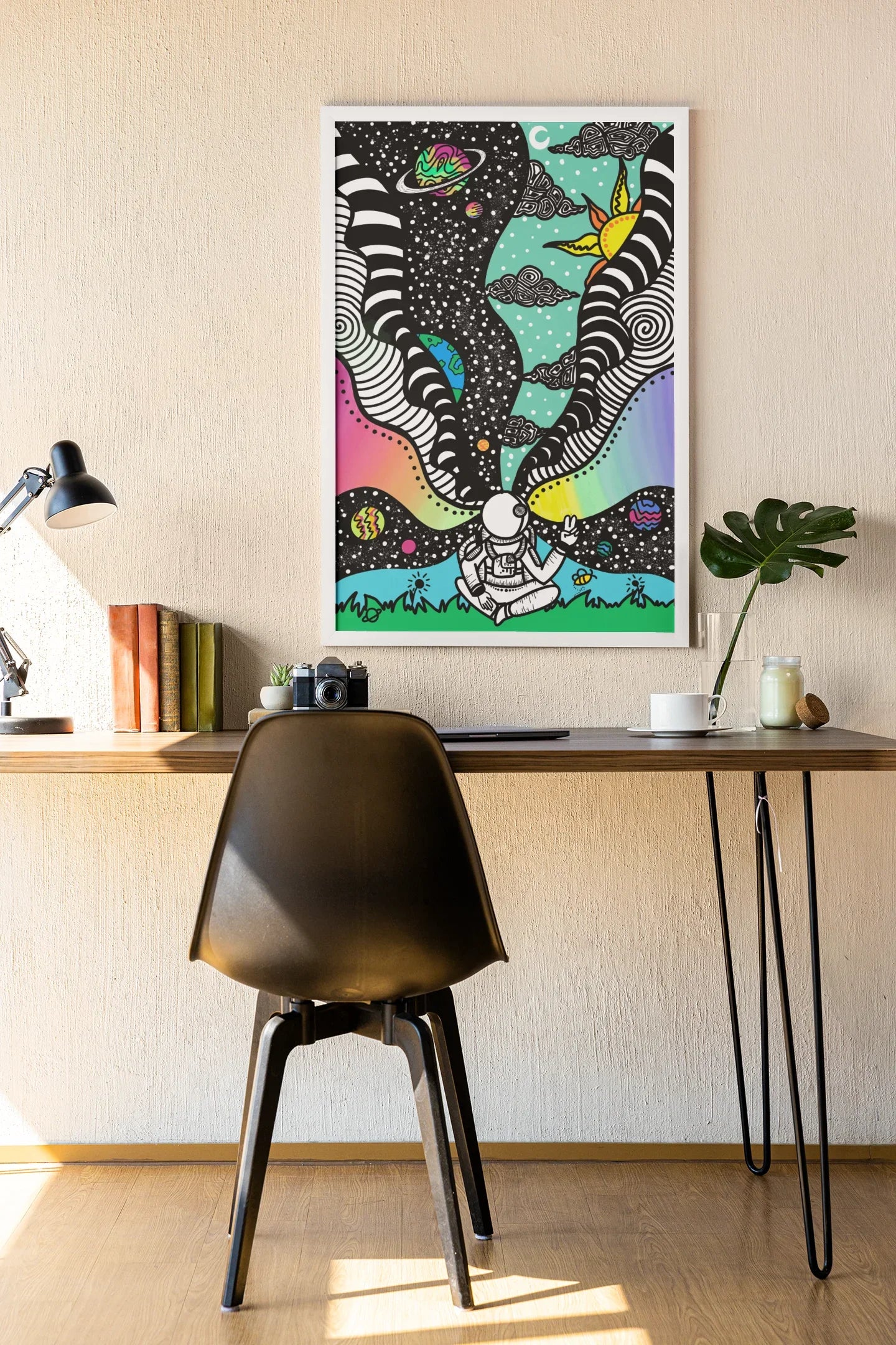 Colorful cosmic art print above desk showing astronaut, planets, rainbow and sun in surreal space landscape