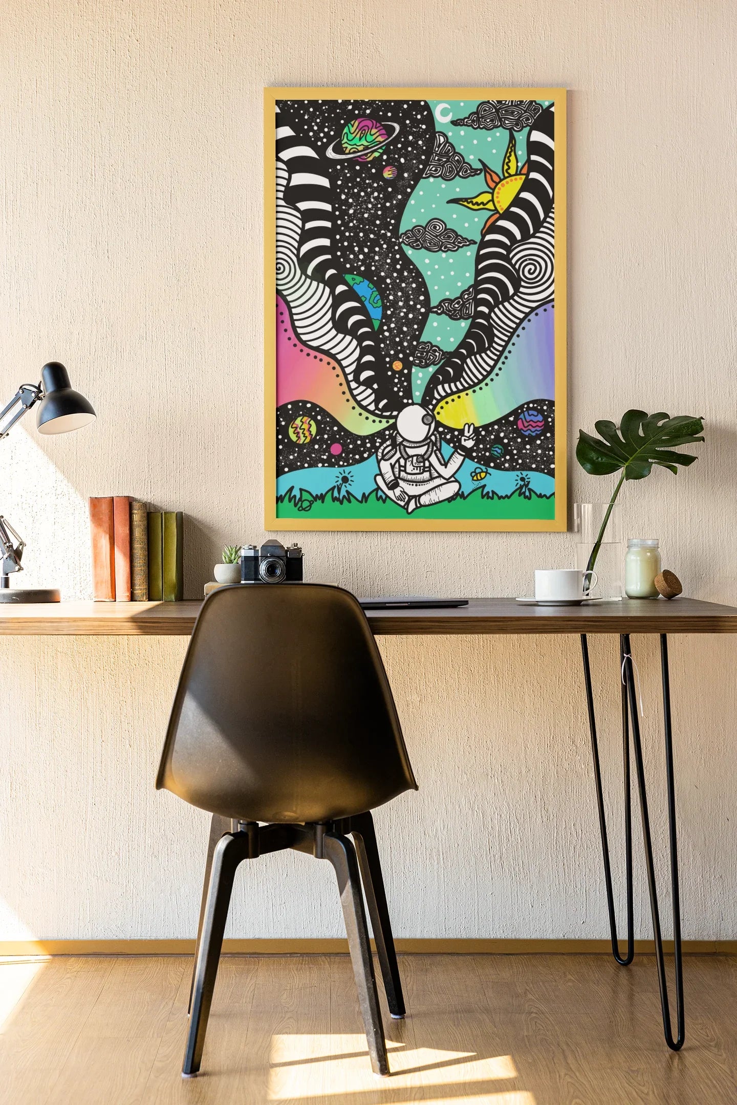 Colorful framed art of an astronaut with space and cosmic patterns above, hanging above a desk